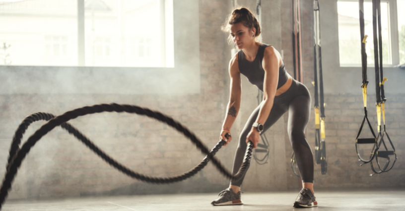 Sportininkė treniruojasi su virvėmis sporto salėje