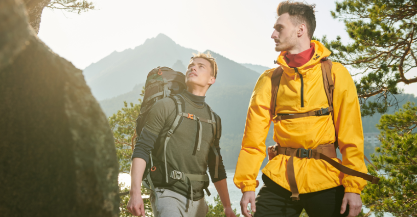 Du vyrai su kuprinėmis žygiuoja kalnuotoje vietovėje