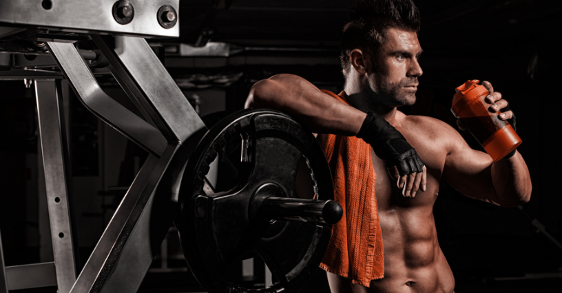 Sporto entuziastas sporto salėje laiko baltymų plaktuvą