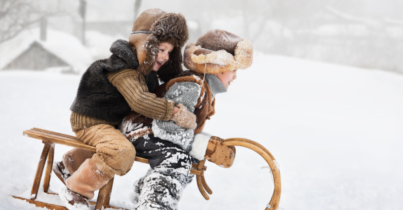 Vaikai roges važiuoja per sniegą