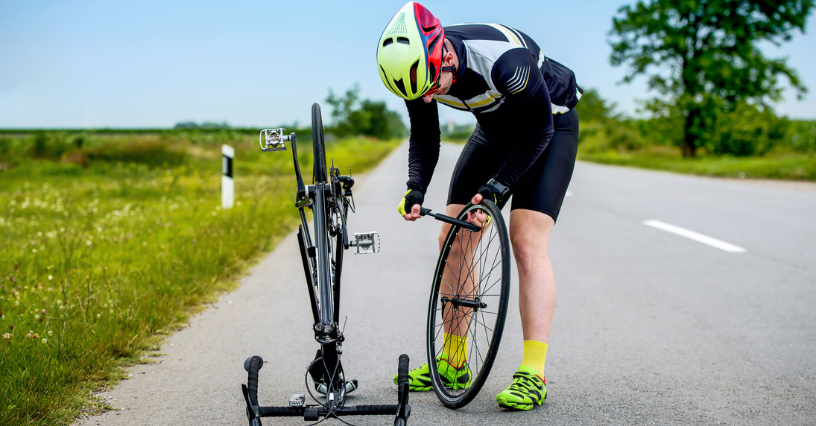 Dviratininkas tvarko savo dviratį pakelėje
