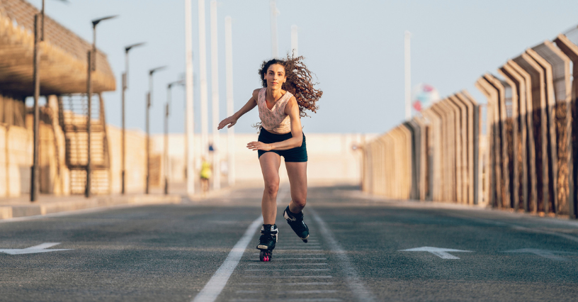 Moterys važiuoja riedučiais keliu