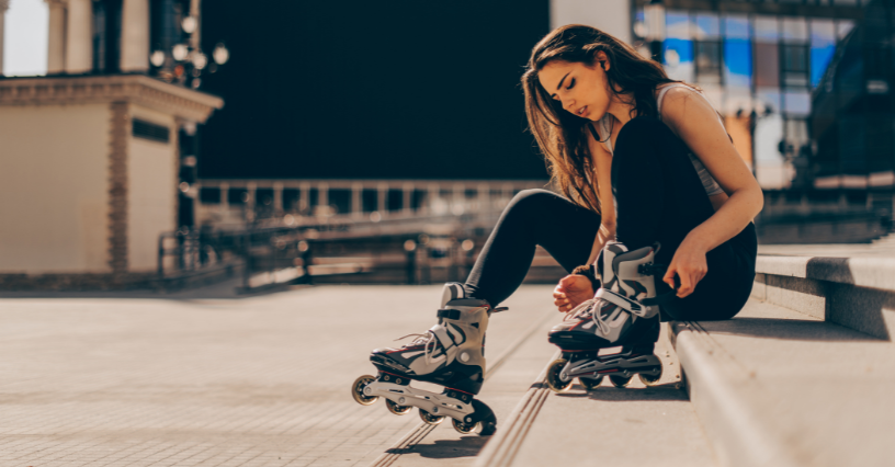 Moteris rengiasi riedučius lauke, sėdėdama ant laiptų