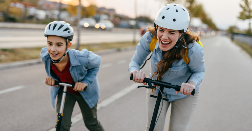 Žmonės važiuoja elektriniais paspirtukais vilkėdami šalmus